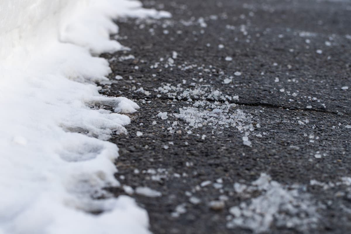 Close up of road with salt for melting snow in winter.